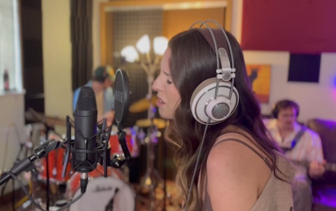 Vocalist recording at a condenser mic in the Monorail Sound studio