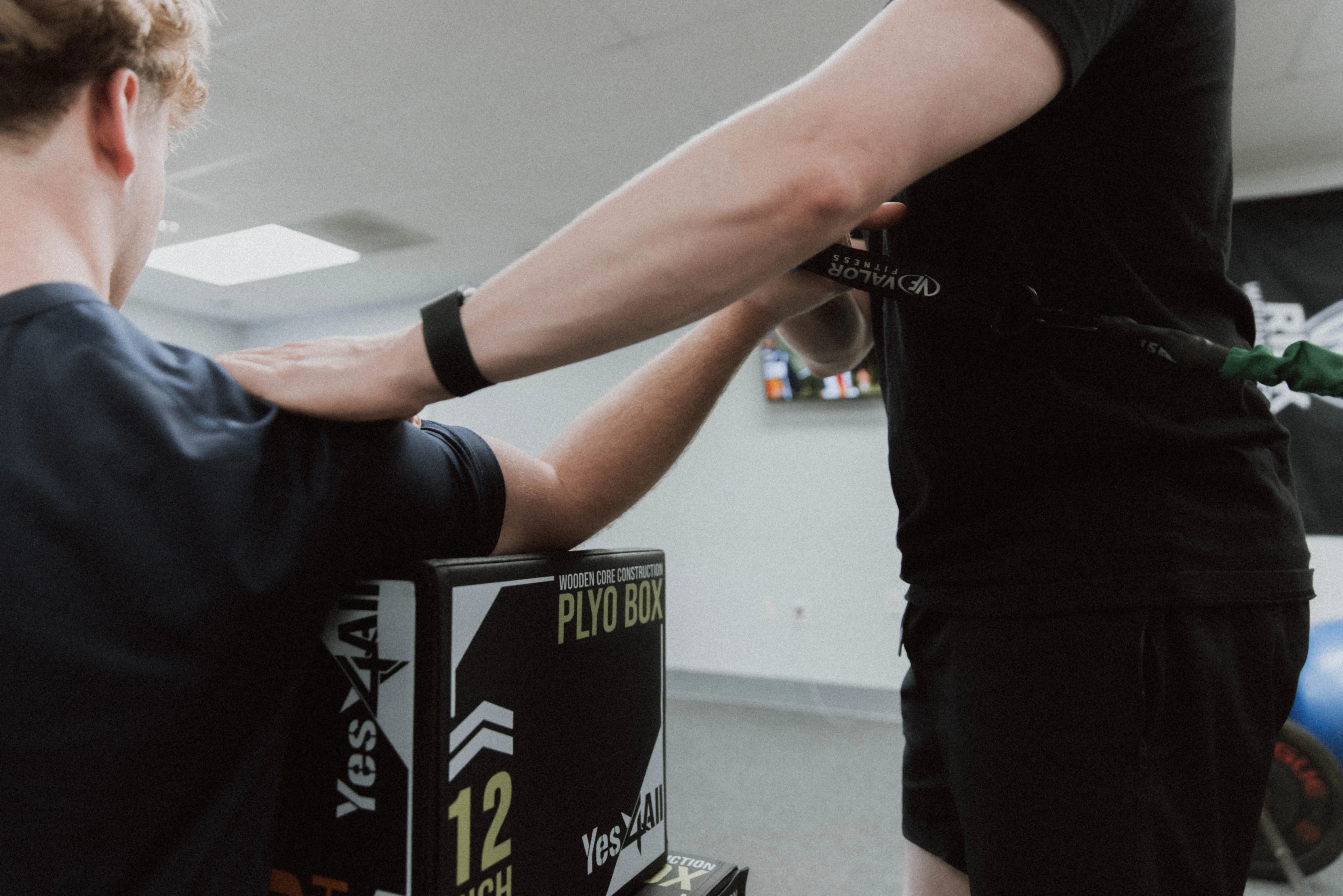 Coach guiding an athlete through strength training at Limitless Physical Therapy